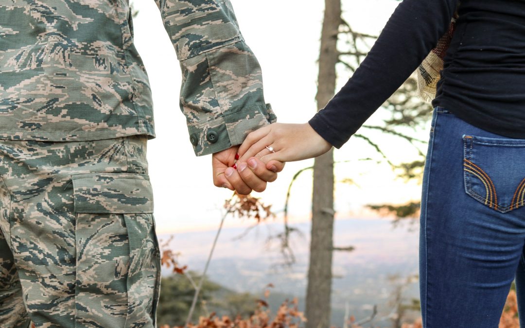 Military couple holding hands to represent military counseling.