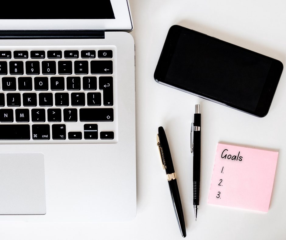 Post it notes next to computer that is titled "Goals" to represent mental health tips mental health tips to align values and goals.