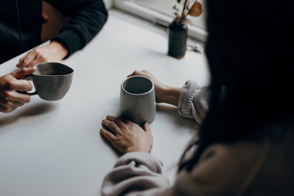 Two people talking over coffee.